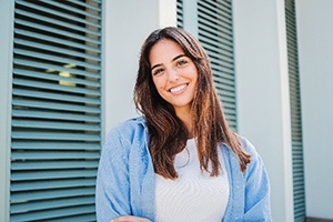 Woman with white teeth smiling while standing outside