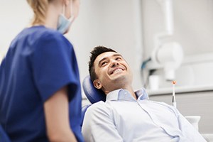 Patient smiling at dental assistant while sitting in treatment chair