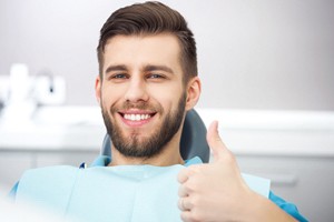 Man gives thumbs up after getting dental implants in Ontario