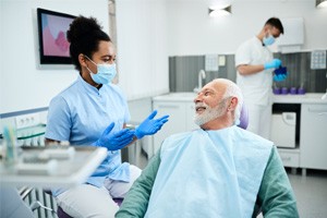 Dentist talking to smiling patient in treatment room