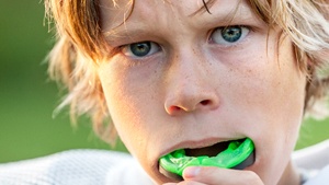 Young football player with an athletic mouthguard. 