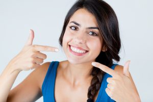 Smiling woman pointing at her teeth