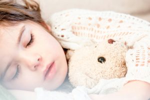 Kids with sleep apnea holding a teddy bear.