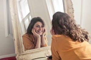 Woman looking at teeth in mirror