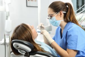 a dental hygienist is happily helping a patient during a checkup